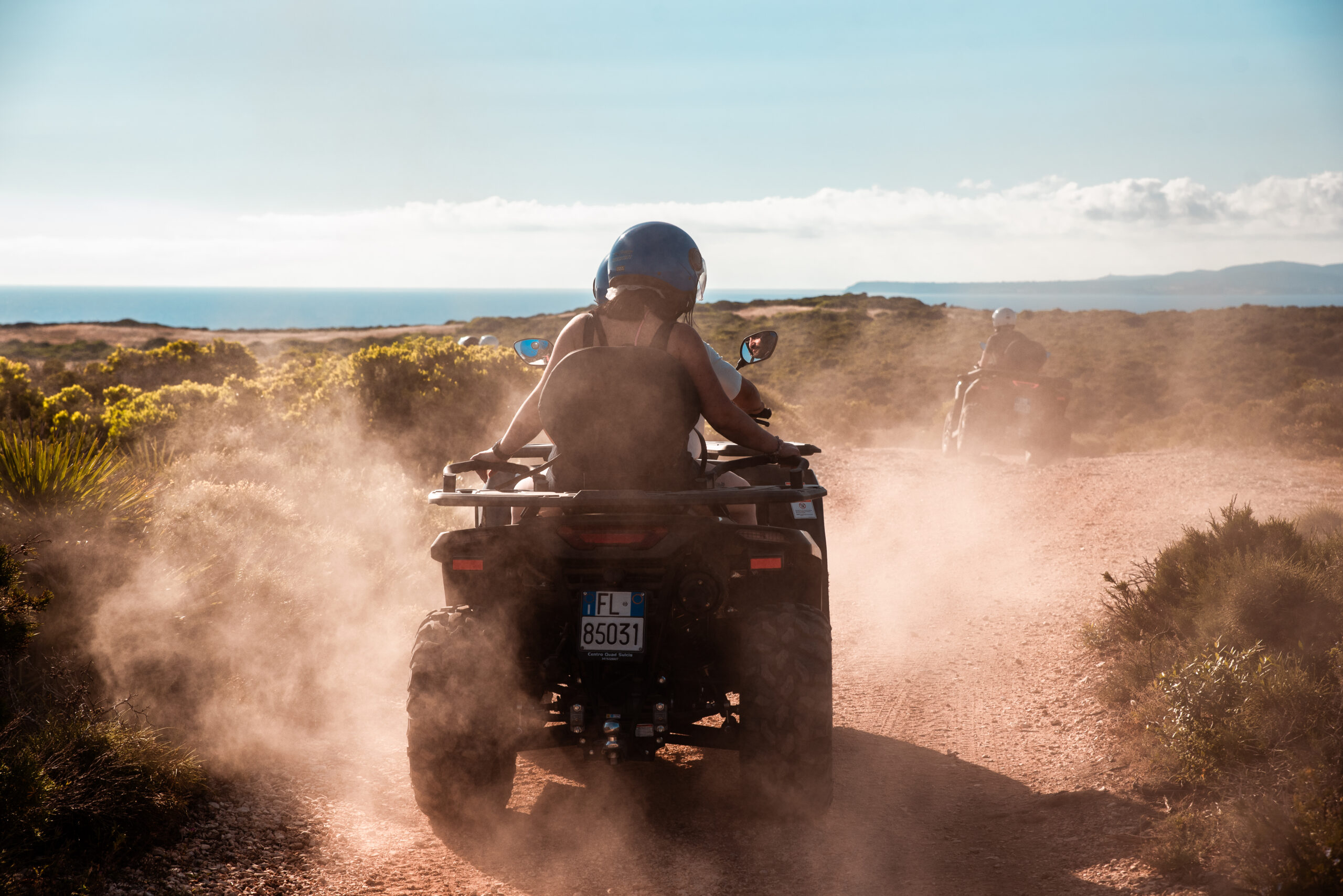 Quad z kierowcą i pasażerem na szutrowej drodze na Sant'Antioco